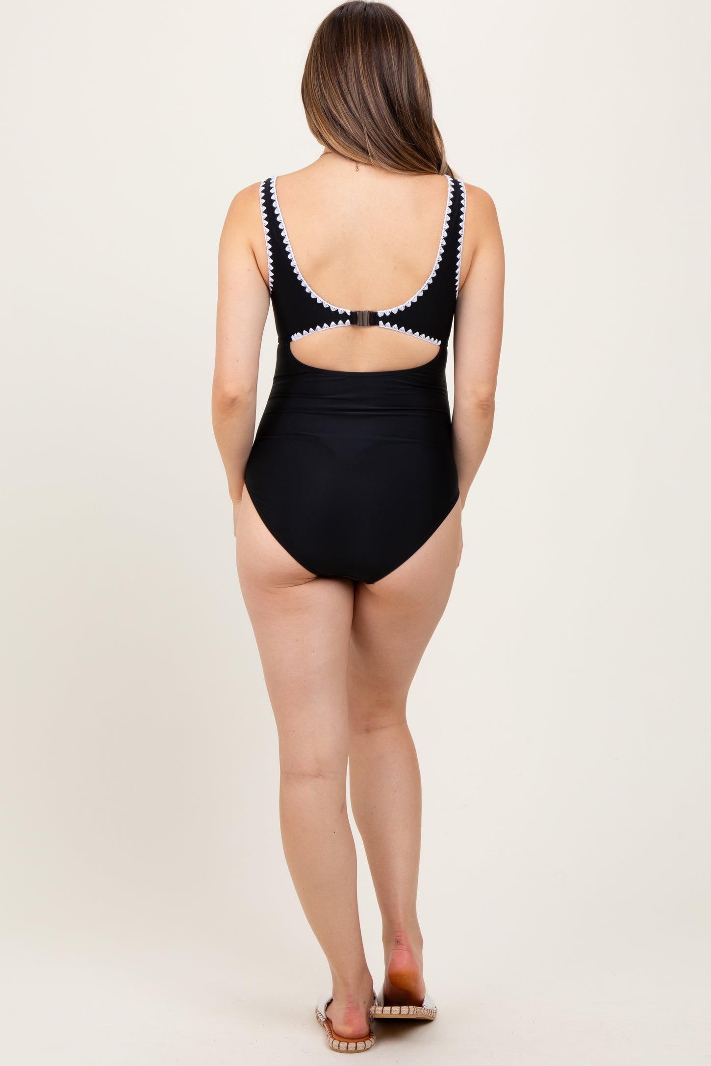maternity wear black one-piece swimsuit with cut-out back detail, model seen from behind