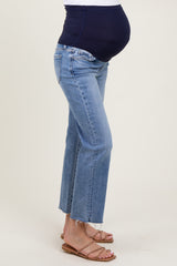 woman wearing light blue maternity cropped jeans with a dark navy belly panel and a visible baby bump