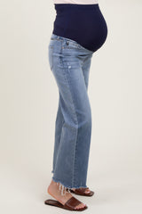 woman wearing light blue maternity jeans with a distressed hem and a navy blue over-the-bump waistband, showing her baby bump