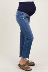 woman wearing dark blue maternity jeans with a distressed hem and a navy over-the-belly waistband, showing her baby bump