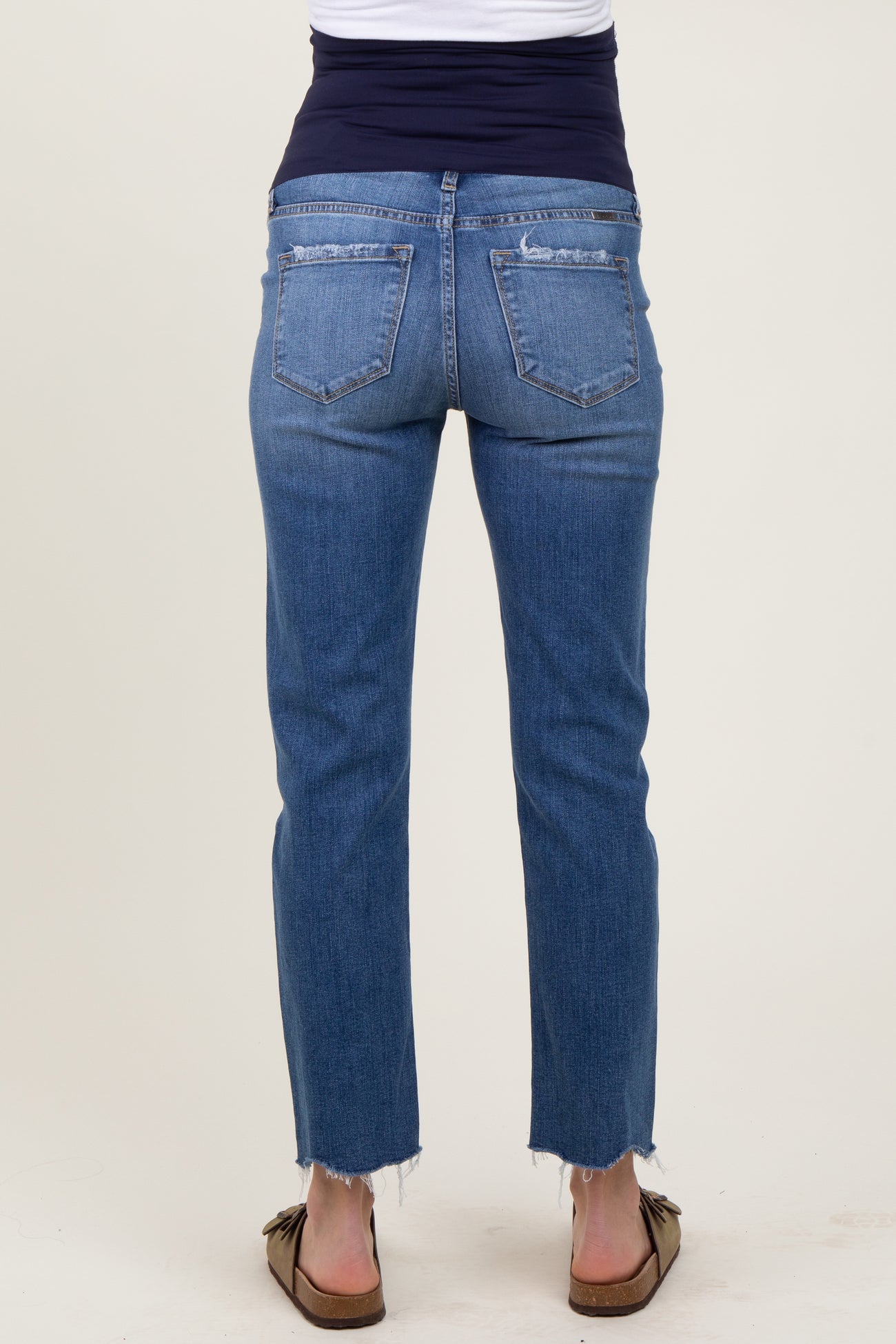 maternity wear woman wearing a pair of blue straight leg jeans with a frayed hem and a stretchy black waistband