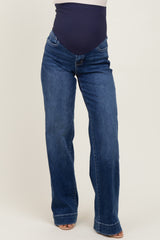 woman wearing dark blue maternity jeans with a fitted belly panel and a flared leg style