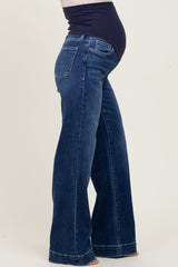 maternity wear in dark wash flared jeans with a supportive over-the-bump band and a visible baby bump