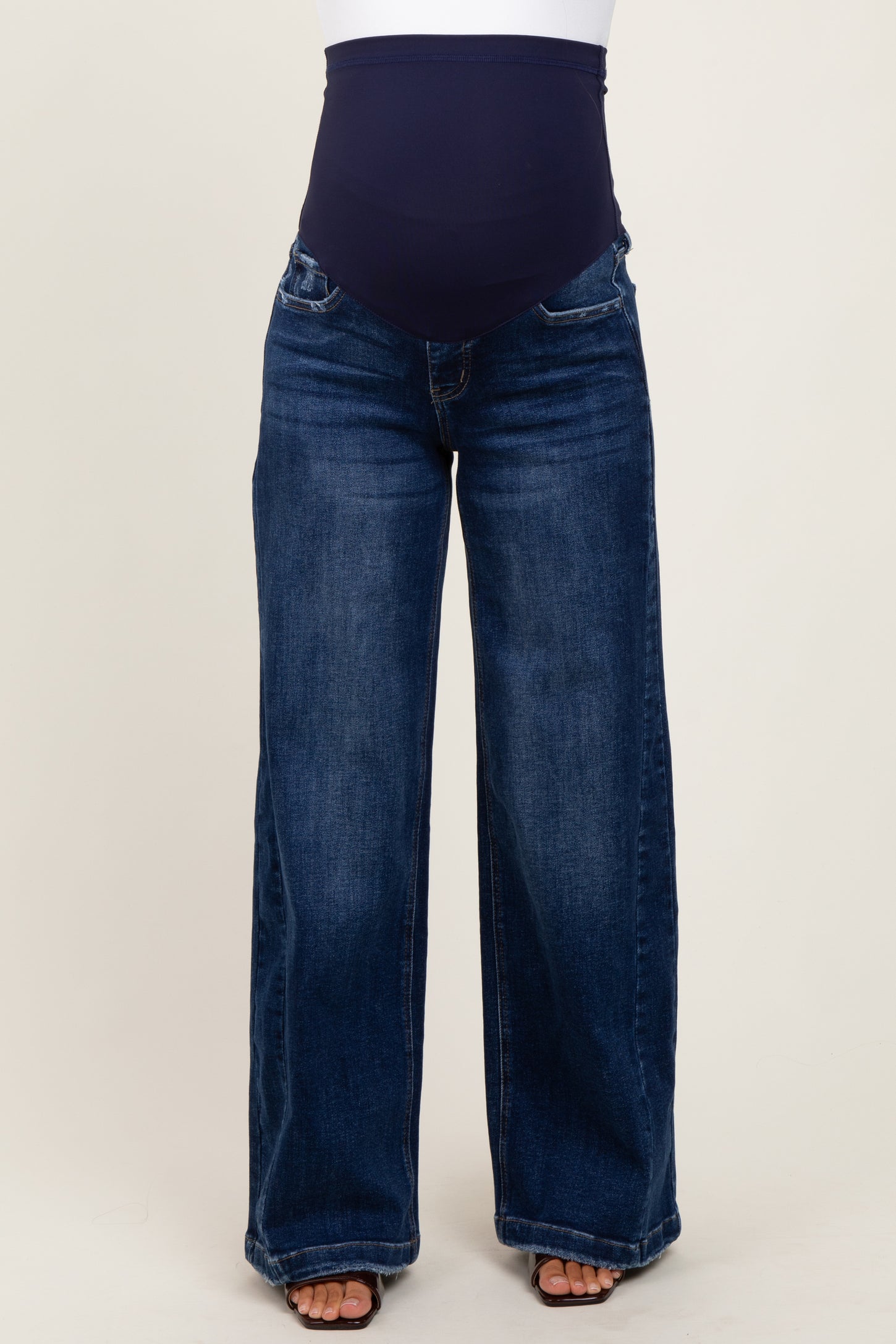woman wearing a pair of dark blue wide-leg maternity jeans with a supportive belly panel