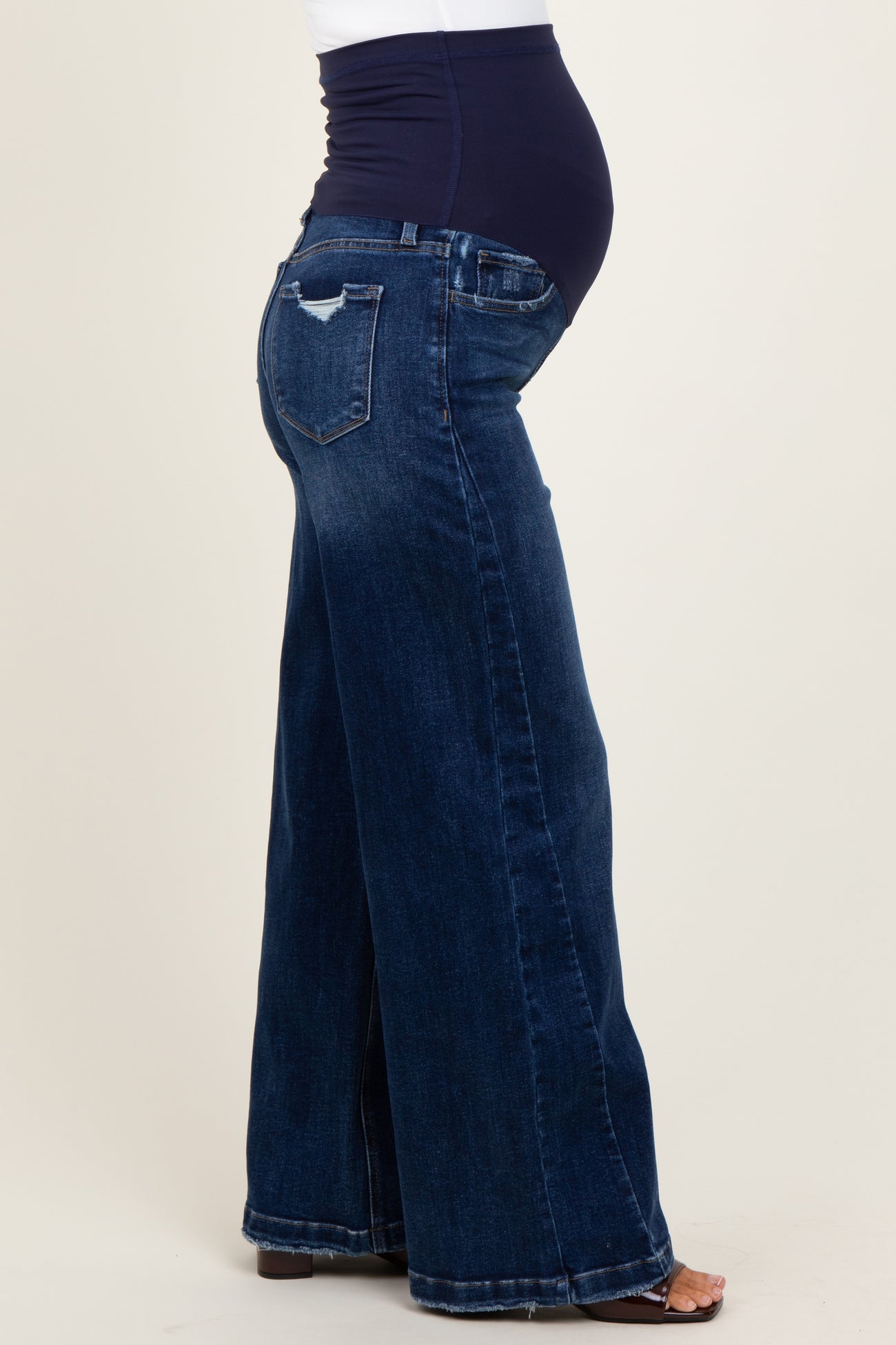 maternity wear featuring wide leg dark blue jeans with a supportive waistband and a visible baby bump
