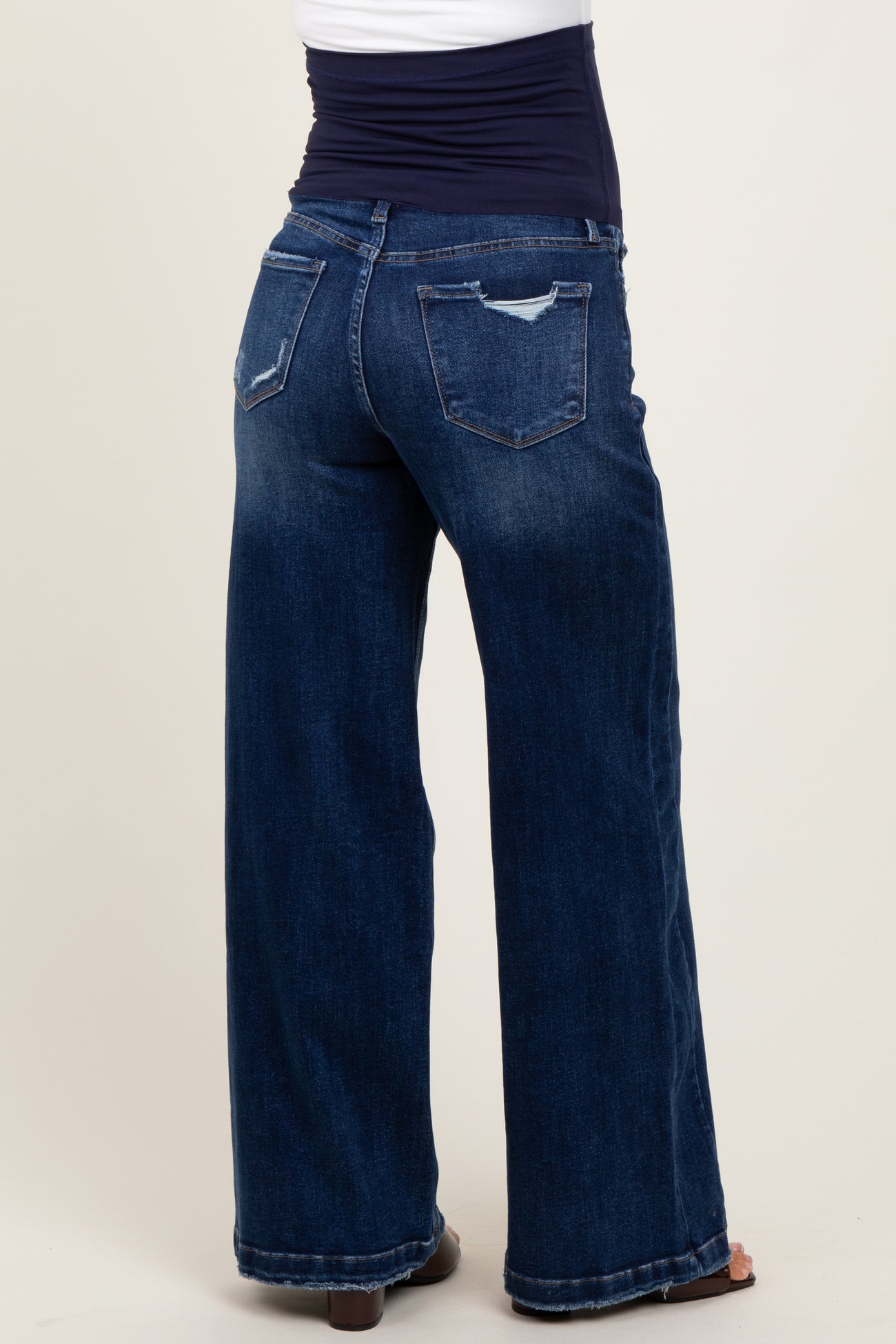 woman wearing dark blue maternity wide-leg jeans with a belly support panel visible from the back