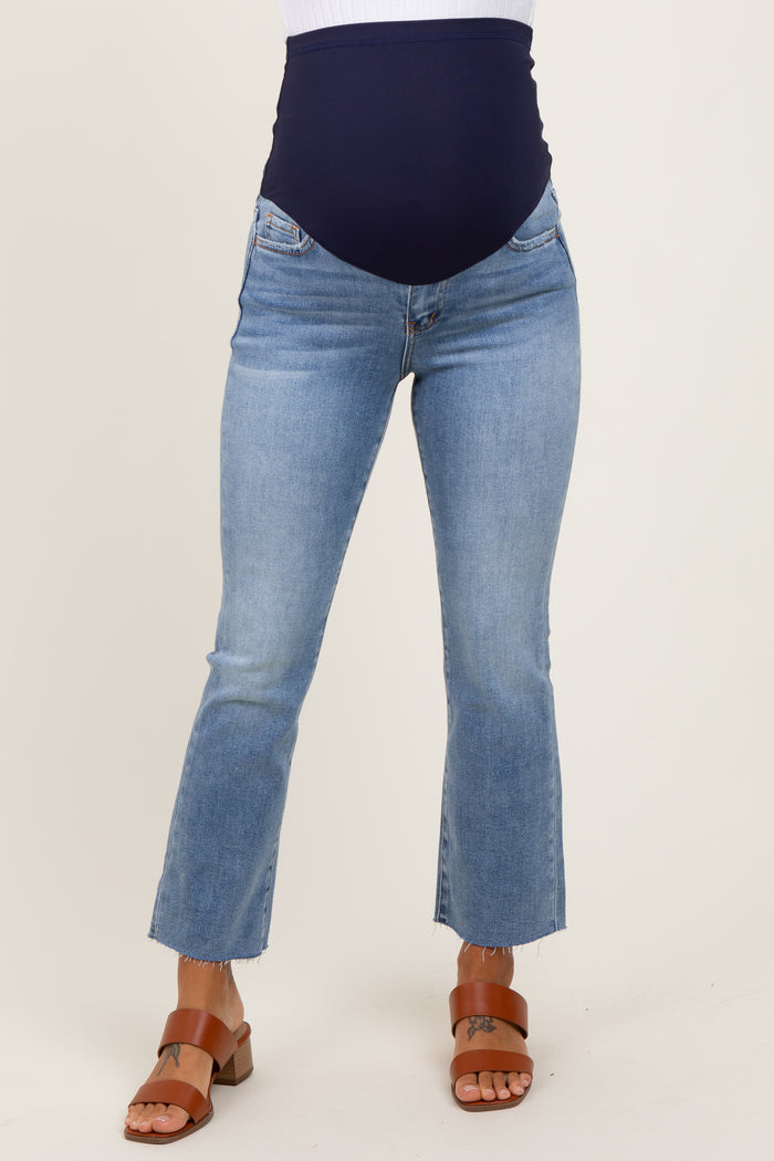 woman wearing light blue maternity jeans with a navy blue over-the-bump panel and cropped hem