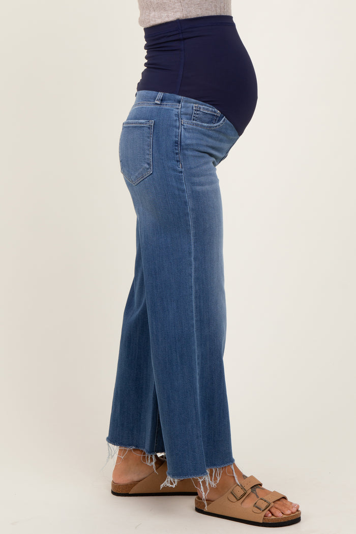 woman wearing a pair of light wash maternity flared jeans with a high waistband and a visible baby bump