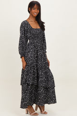 woman wearing a black floral long sleeve maxi dress with a smocked bodice and tiered skirt