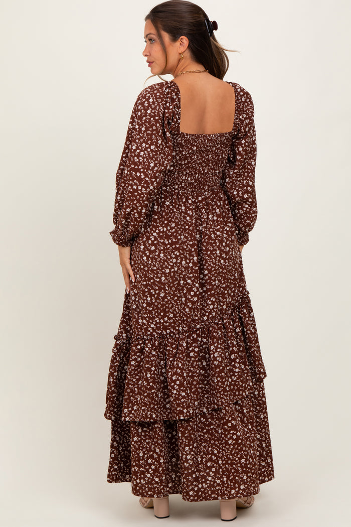woman wearing a brown floral maternity maxi dress with a square back and tiered ruffle detail