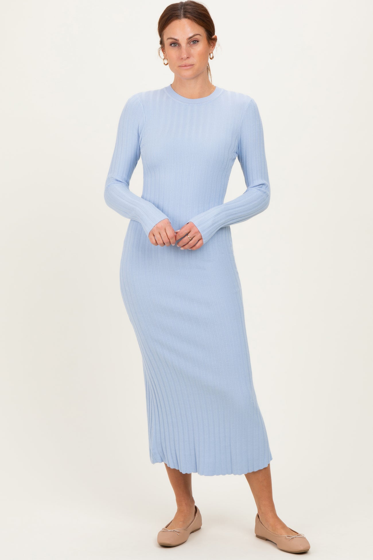 woman wearing a light blue ribbed long sleeve midi dress with a fitted silhouette and round neckline