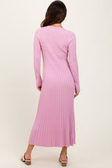 woman wearing a pink ribbed long sleeve maxi dress with a fitted silhouette