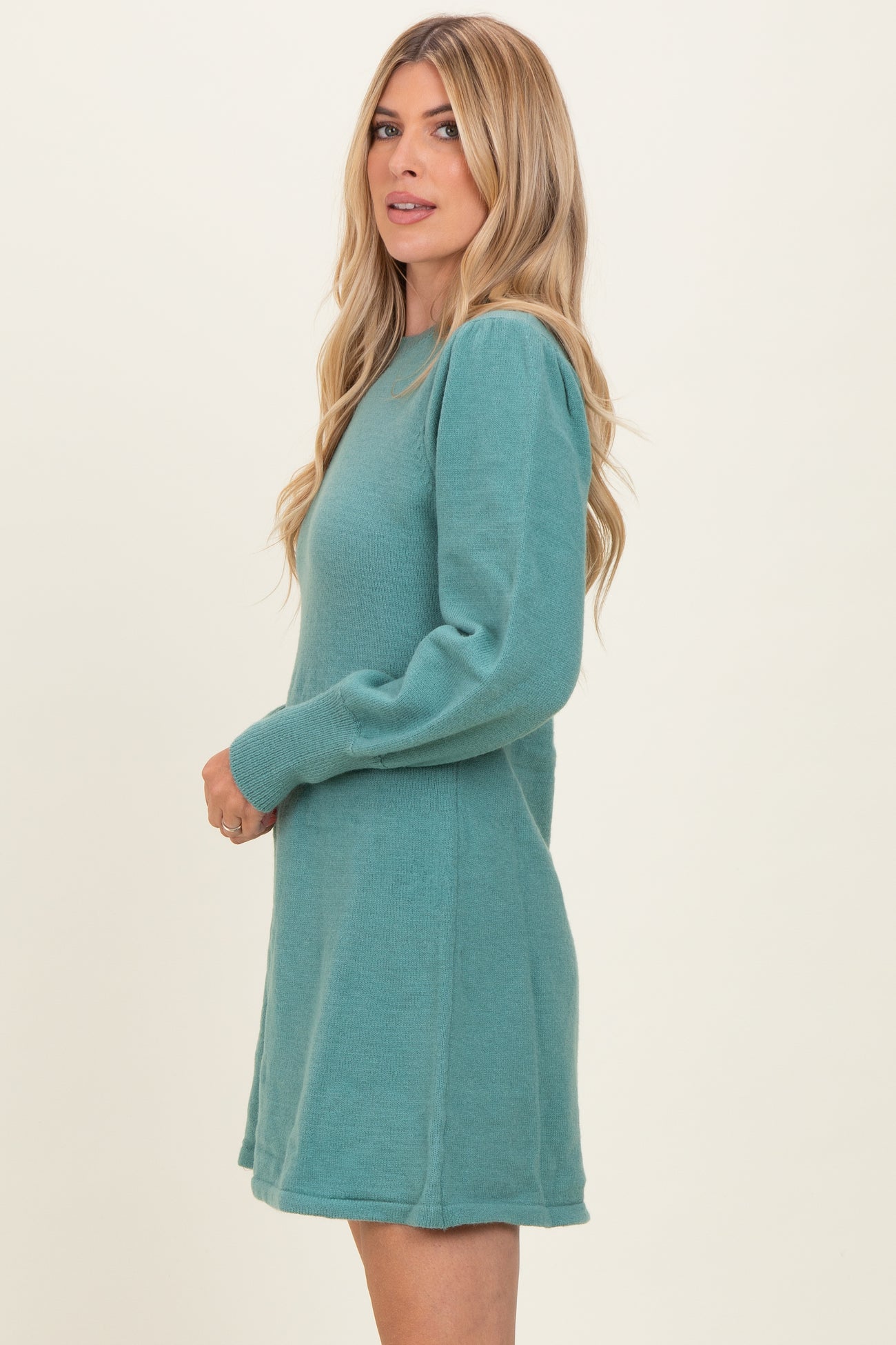woman wearing a teal long sleeve sweater dress with a relaxed fit and side seam details