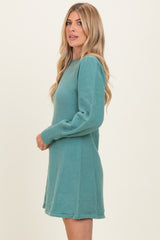 woman wearing a teal long sleeve sweater dress with a relaxed fit and side seam details