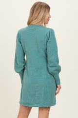 woman wearing a teal long sleeve sweater dress with puffed sleeves, viewed from the back