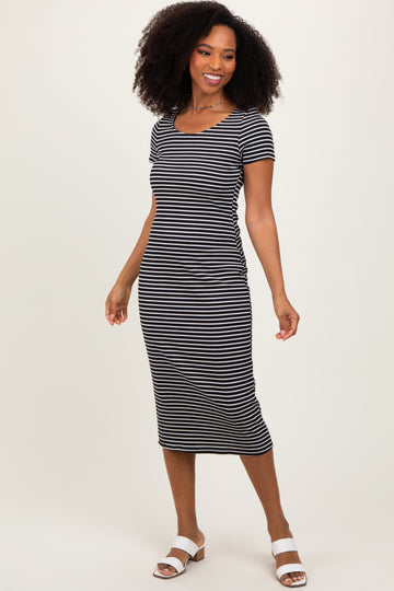 woman wearing a black and white striped short sleeve midi dress with a scooped neckline and a fitted silhouette