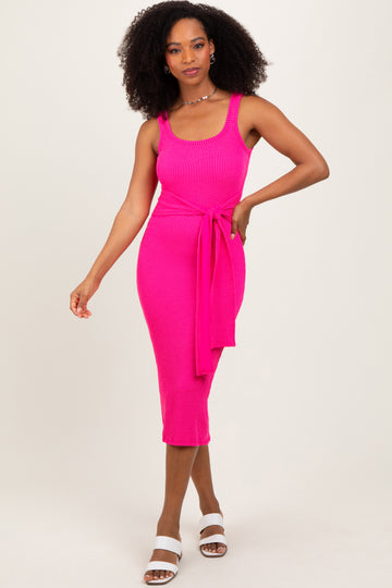 woman wearing a bright pink ribbed midi dress with a fitted silhouette and tie detail at the waist