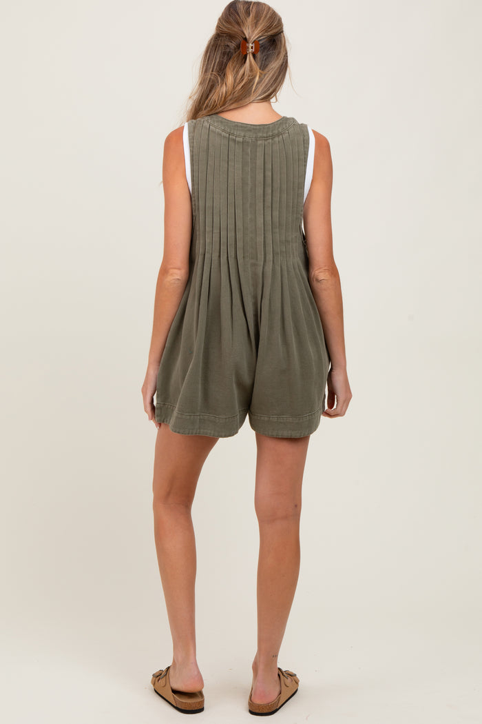 woman wearing a green maternity romper with pleated back and casual shorts style