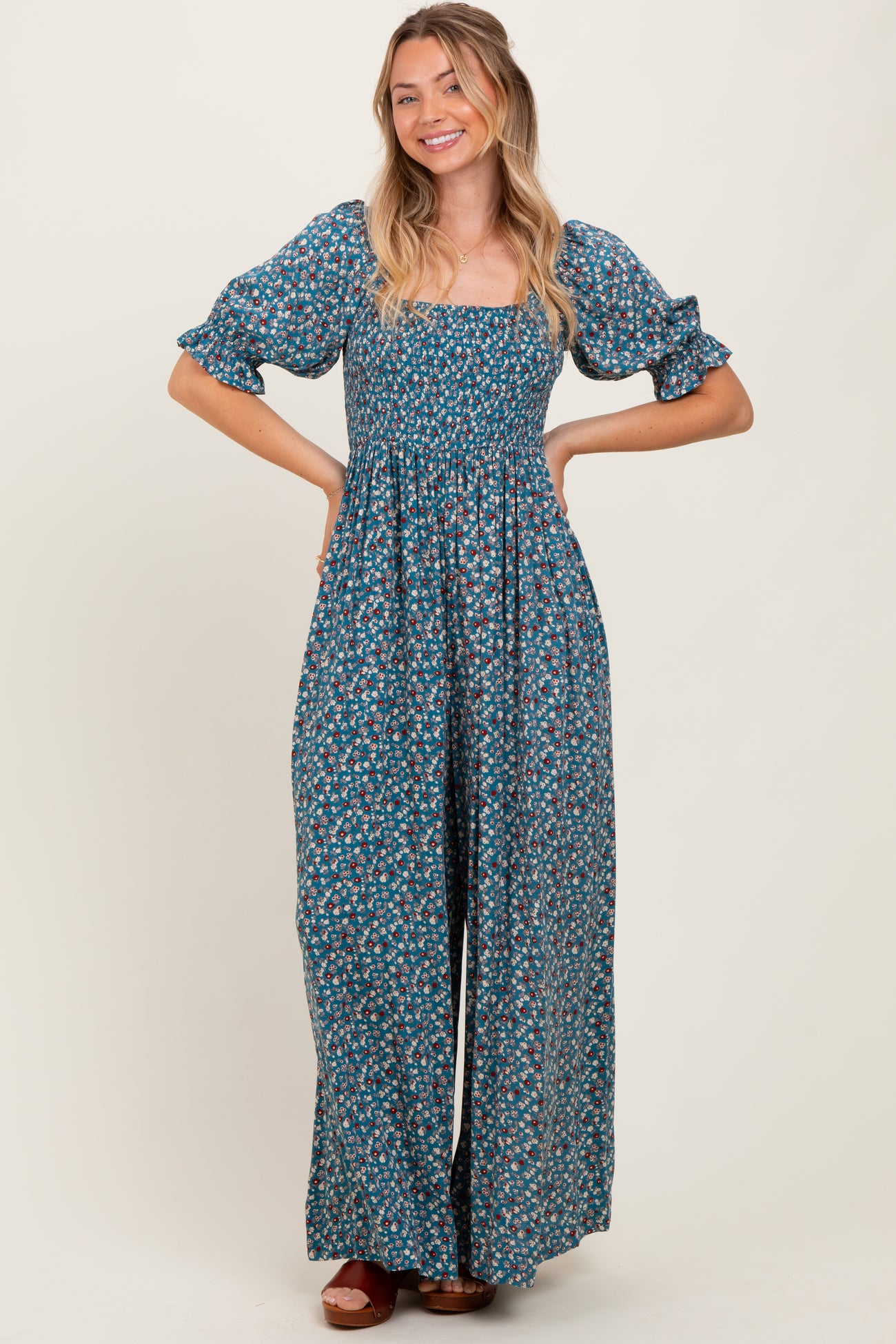 woman wearing a green floral maxi dress with puff sleeves and a square neckline