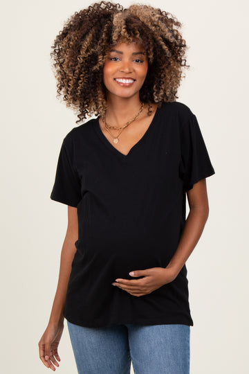 woman wearing a black v-neck maternity top and holding her baby bump