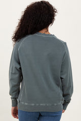 woman wearing a cozy green sweatshirt with a relaxed fit and ribbed cuffs, shown from the back
