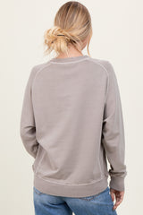 woman wearing a taupe cozy sweatshirt with a relaxed fit and ribbed cuffs, seen from the back