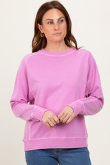 woman wearing a pink long sleeve sweatshirt with ribbed cuffs and hem, styled casually with blue jeans