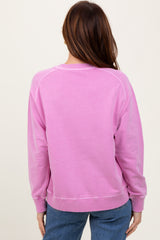 woman wearing a pink oversized sweatshirt with ribbed cuffs and hem, viewed from the back