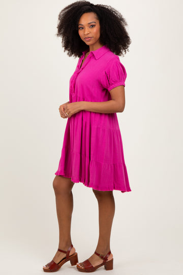 woman wearing a bright pink short sleeve tiered dress with a collared neckline and puff sleeves