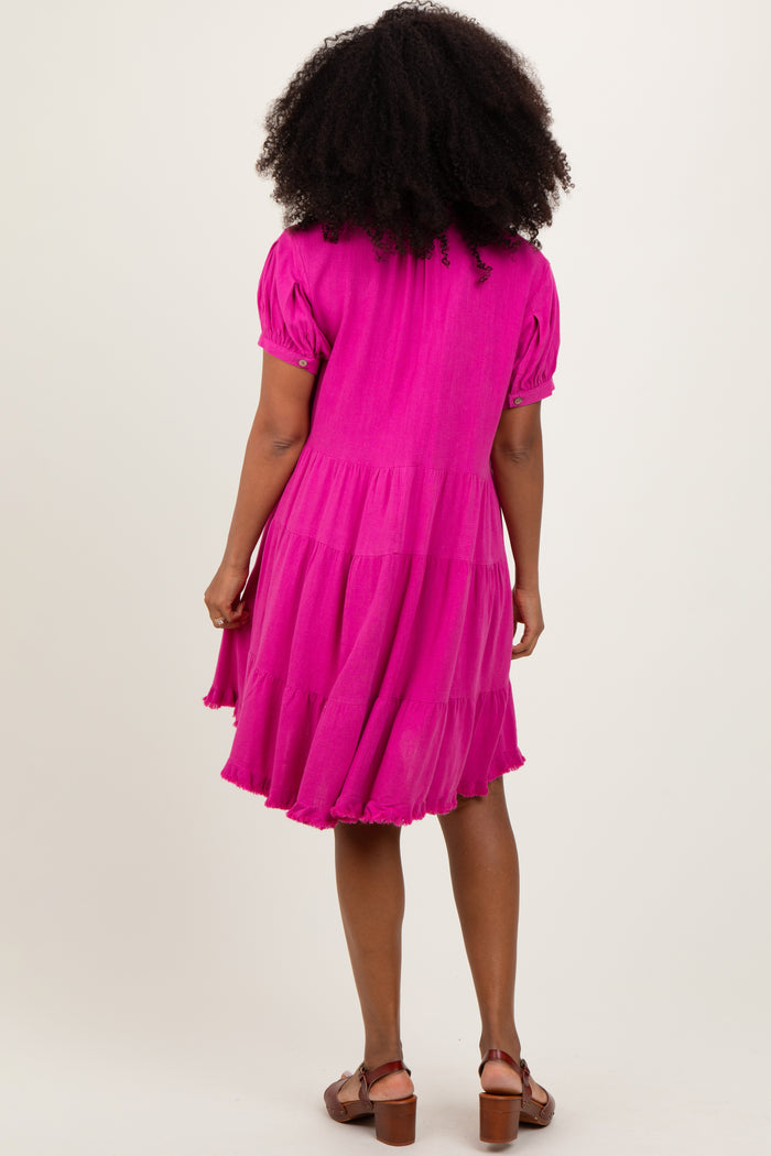 woman wearing a bright pink puff sleeve tiered dress, showing the back view, with natural curly hair and sandals