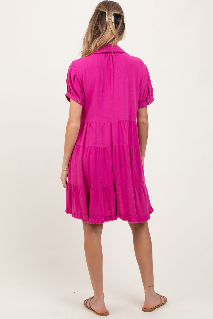 woman wearing a vibrant pink short sleeve maternity dress with a tiered hem, showing her baby bump from the back