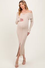 woman wearing a beige off-the-shoulder maternity dress with buttons and a slit, showcasing her baby bump