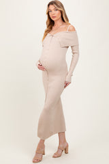 woman wearing a light beige off-the-shoulder maternity dress with buttons and a fitted silhouette, cradling her baby bump