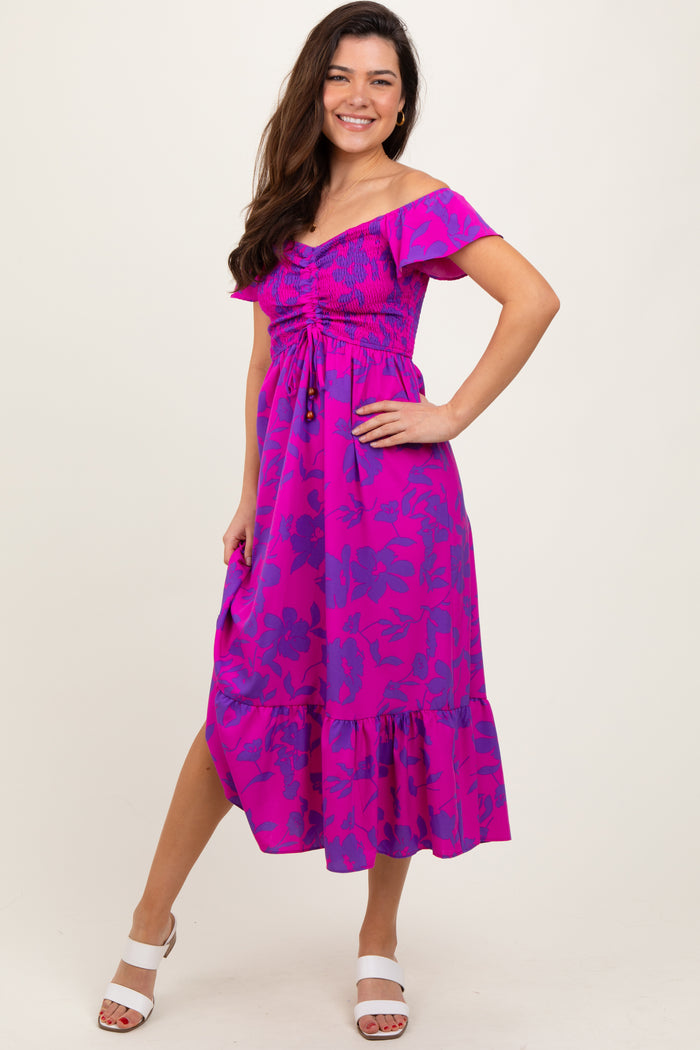 woman wearing a vibrant pink floral off-shoulder midi dress with smocked bodice and ruffled hemline