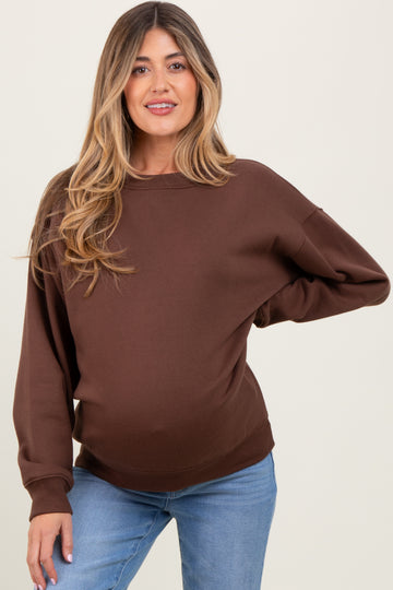 woman wearing a brown maternity sweatshirt with relaxed fit and long sleeves, showing her baby bump