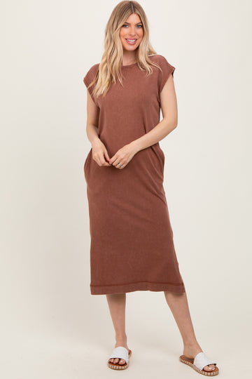 woman wearing a brown sleeveless maxi dress with side pockets and white slide sandals