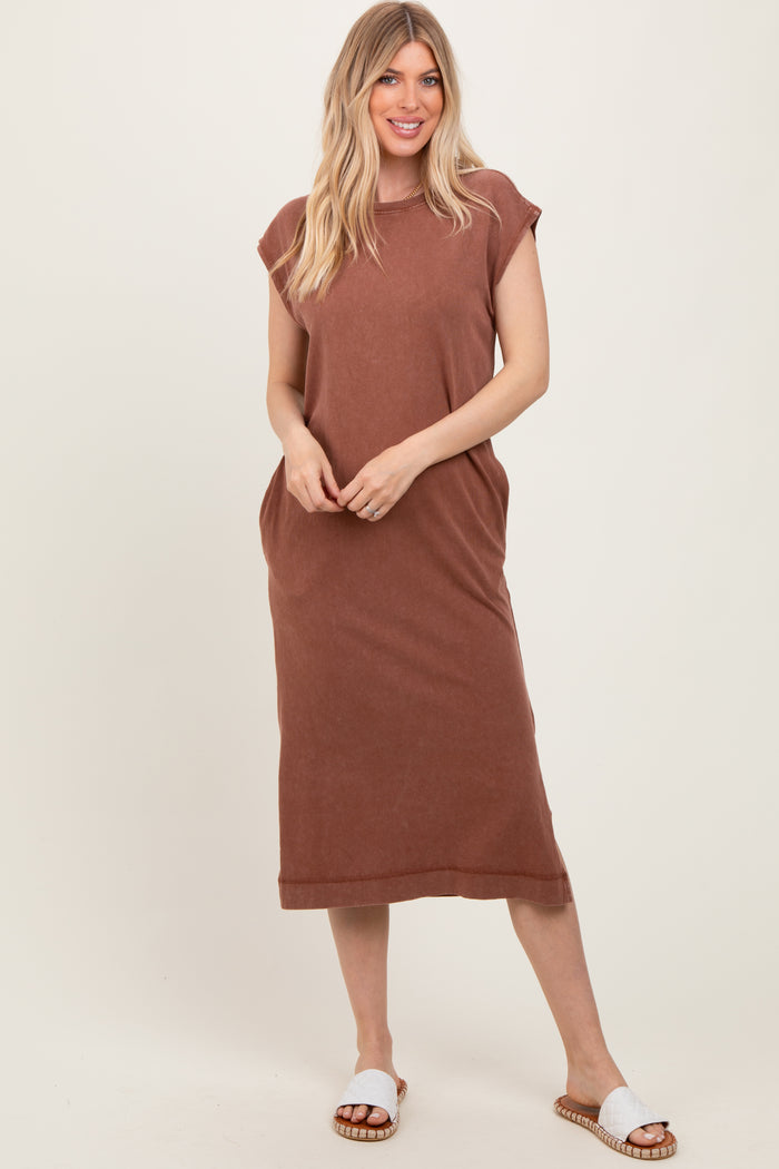 woman wearing a brown sleeveless maxi dress with side pockets and white slide sandals