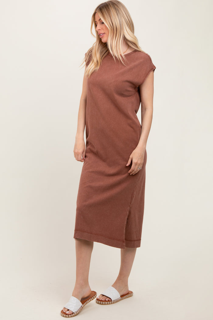 woman wearing a rust-colored sleeveless midi dress with side slits and styled with white slide sandals