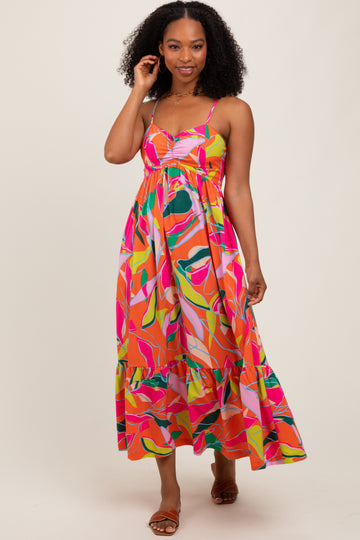 woman wearing a multicolored floral pattern maxi dress with spaghetti straps and a tiered skirt