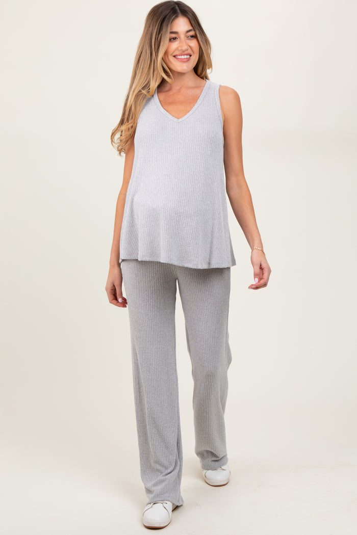 woman wearing a light gray ribbed maternity top and matching pants, showing her baby bump