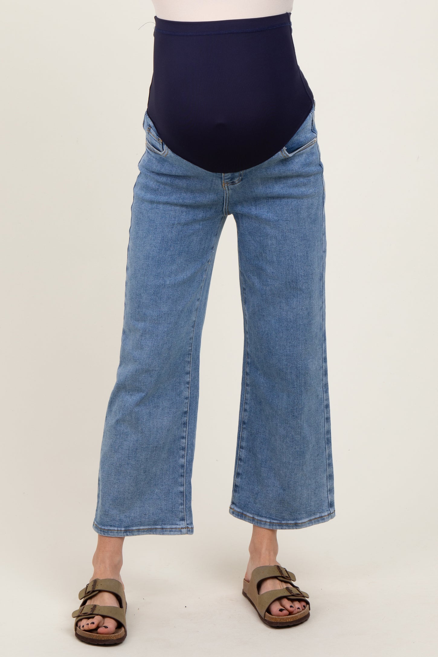 woman wearing a pair of blue maternity jeans with a dark blue over-the-bump panel