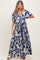 woman wearing a navy floral maxi maternity dress with a tie front and short sleeves, showing her baby bump