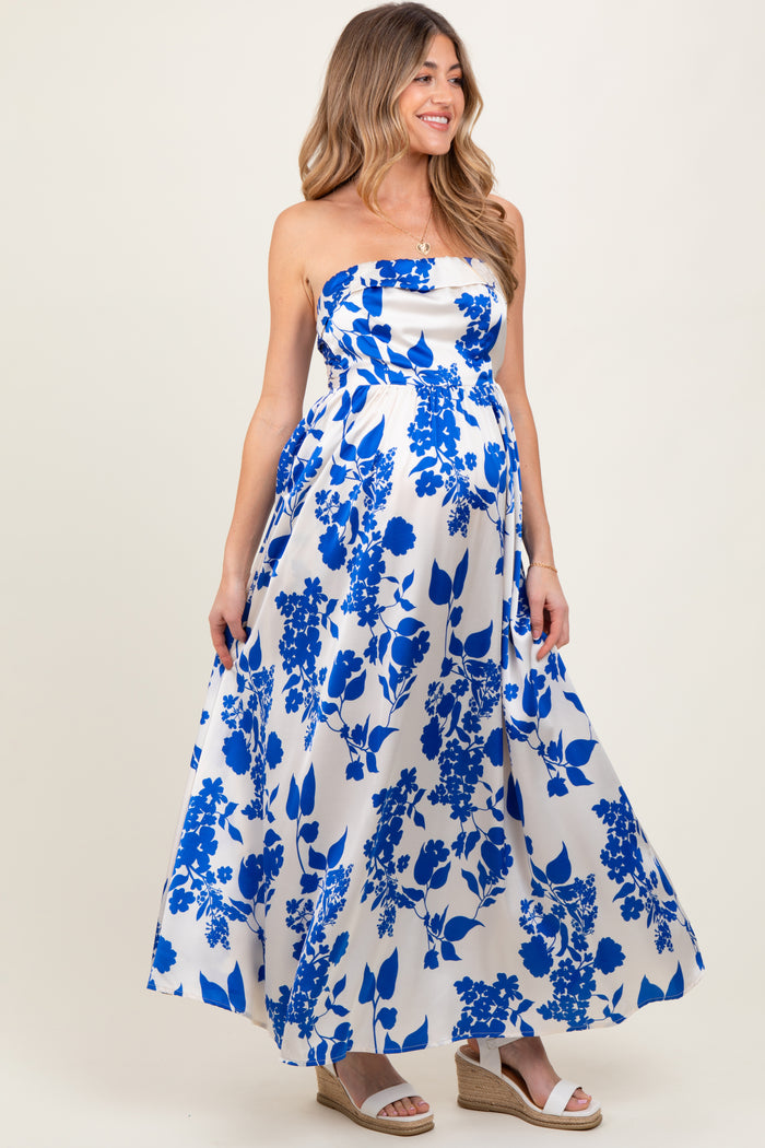 woman wearing a floral print strapless maternity maxi dress with a fitted bodice and flowing skirt, showcasing her baby bump