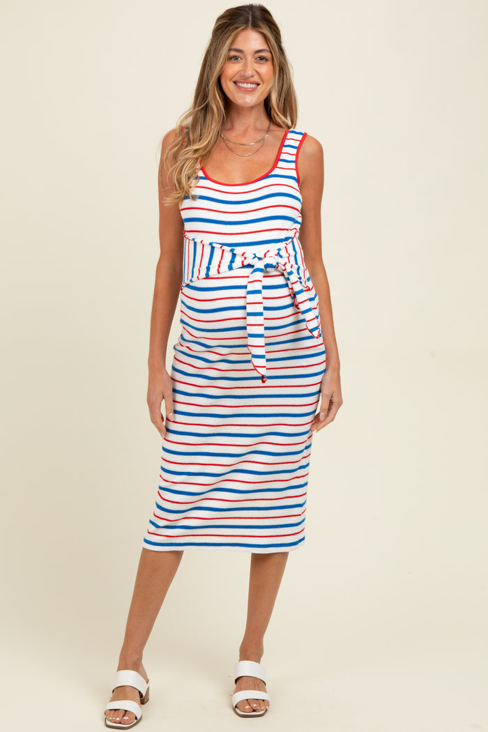 woman wearing a striped maternity dress with a tie waist, featuring red, blue, and white stripes and a visible baby bump