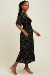 woman wearing a black floral midi dress with short puff sleeves and a smocked bodice, walking in clear heeled sandals