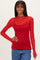 woman wearing a red long sleeve top with black heart print and sheer fabric details