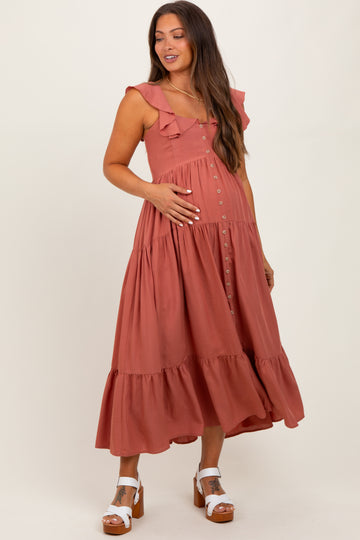 woman wearing a dusty rose maternity dress with ruffle straps and button details, holding her baby bump