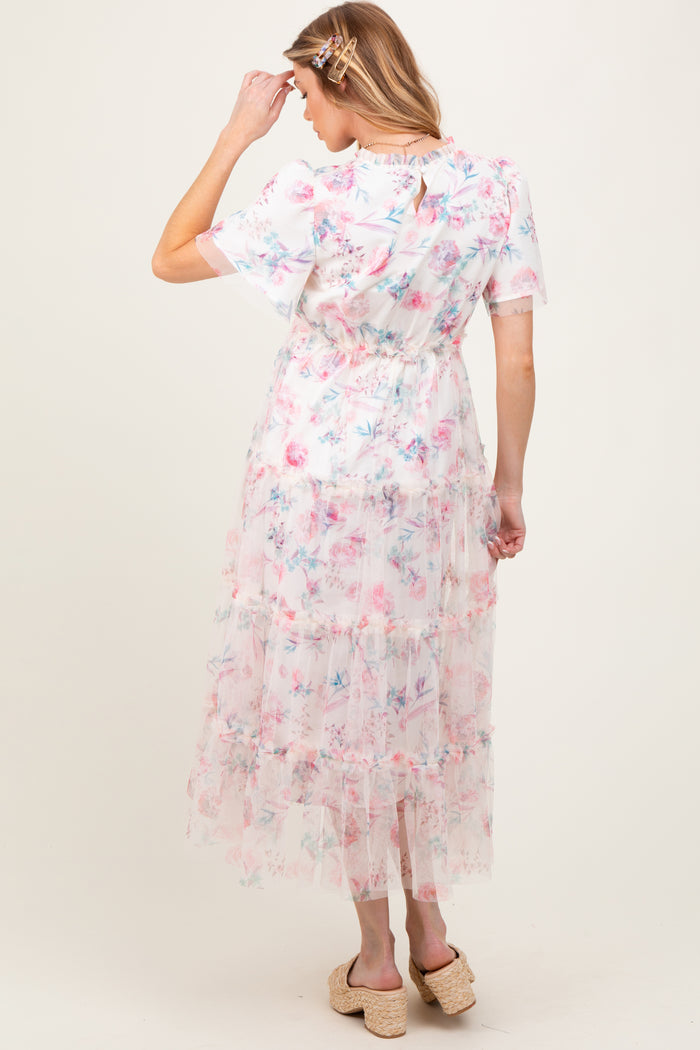 woman wearing a floral maternity maxi dress with tiers and short sleeves, viewed from the back
