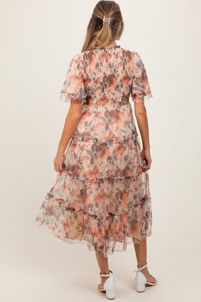 woman wearing a floral maternity maxi dress with tiered ruffles and short sleeves, showing her baby bump from the back