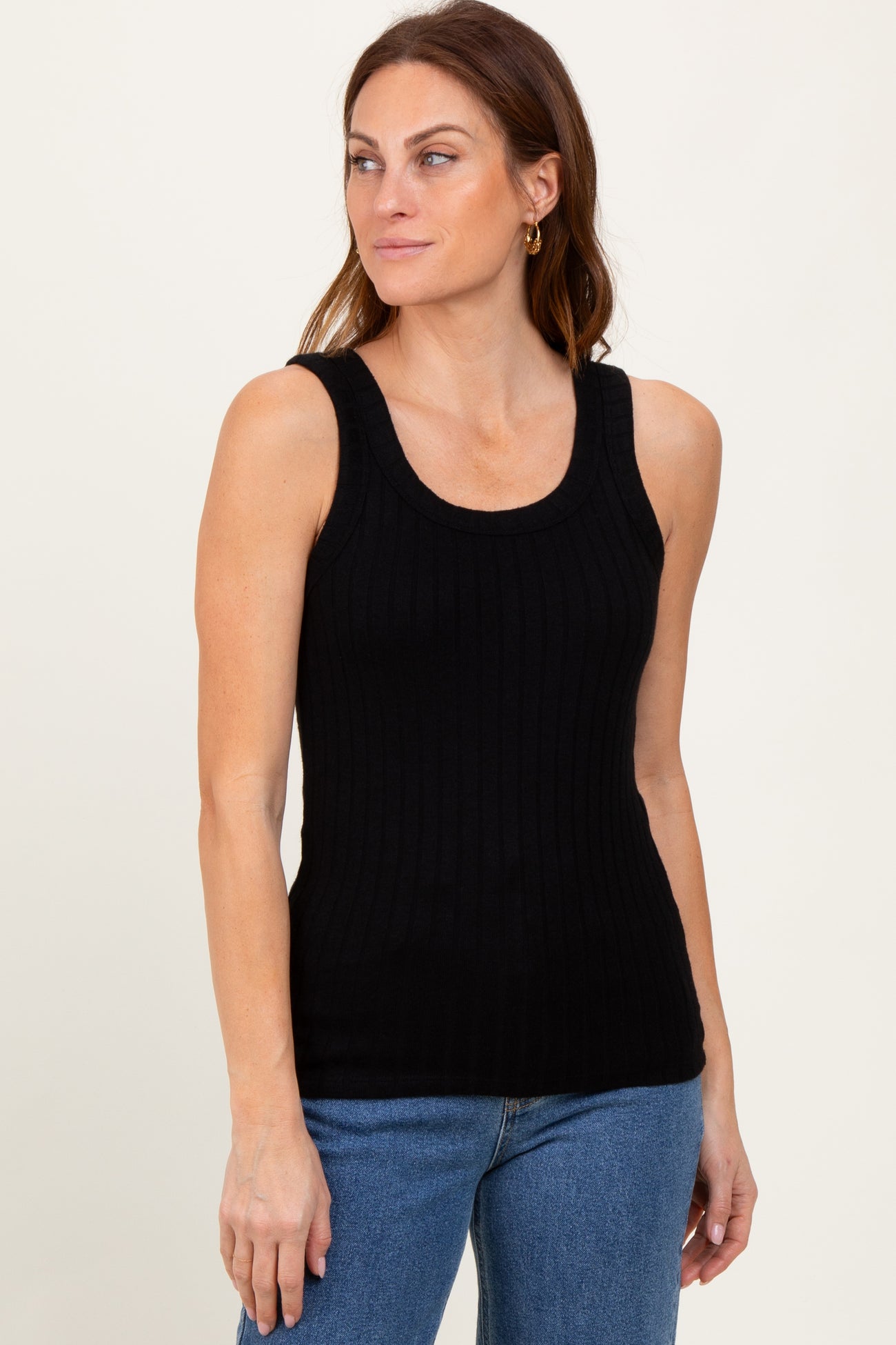 woman wearing a black ribbed sleeveless top paired with blue jeans